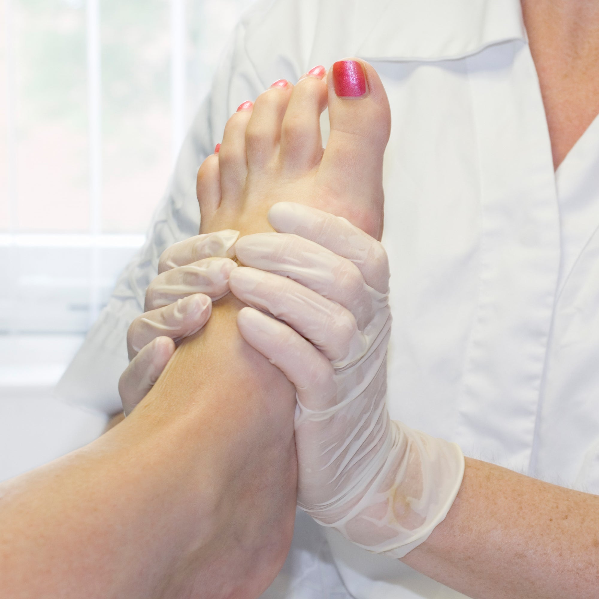Podiatrist holding a person's foot during a pedicure treatment