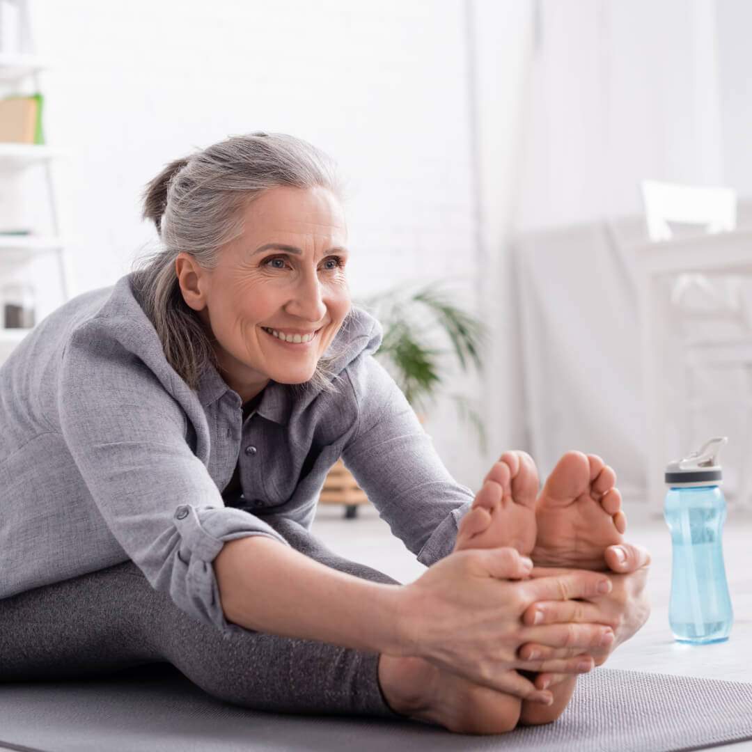Middle aged woman stretching and holding her feet