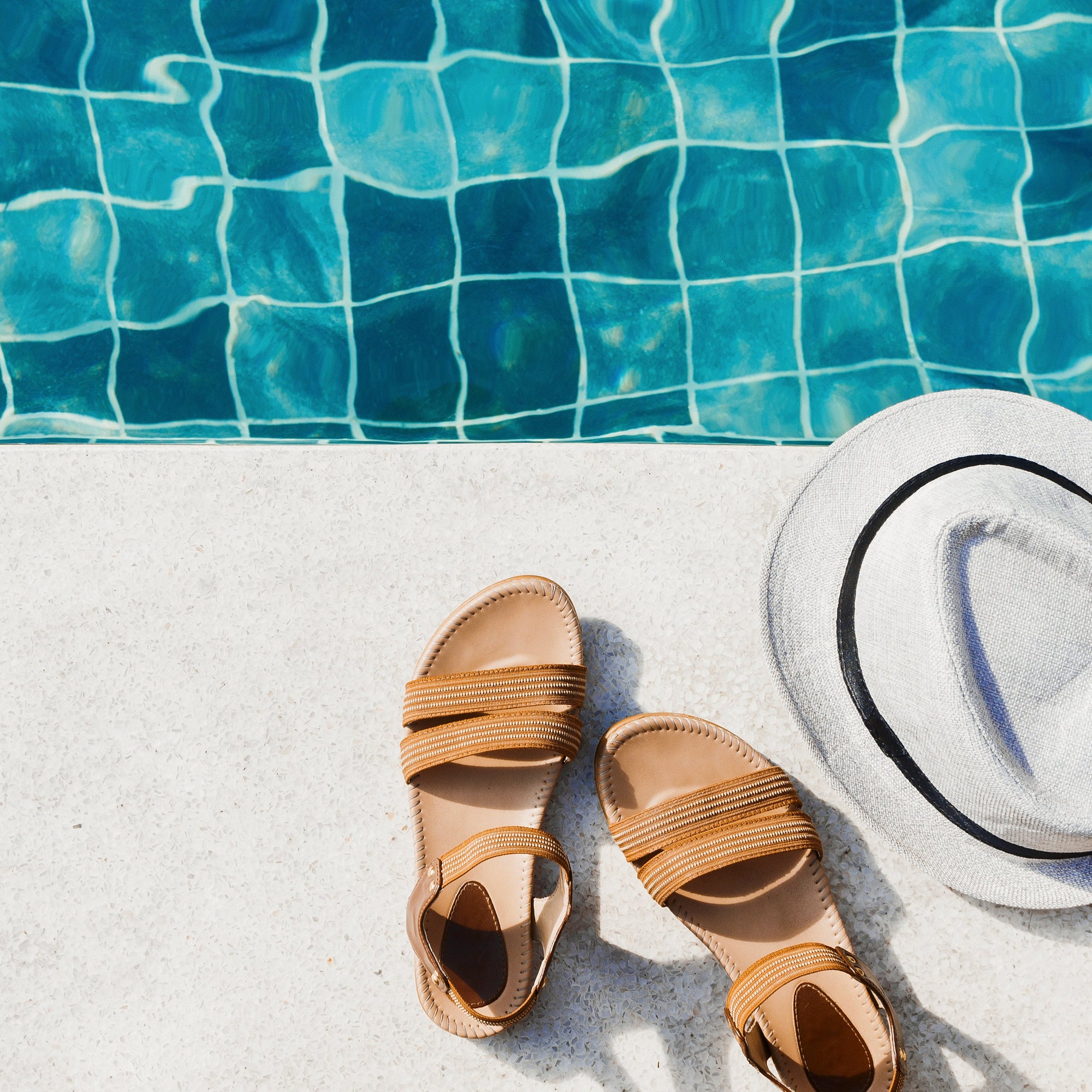 Sandals and hat by the pool