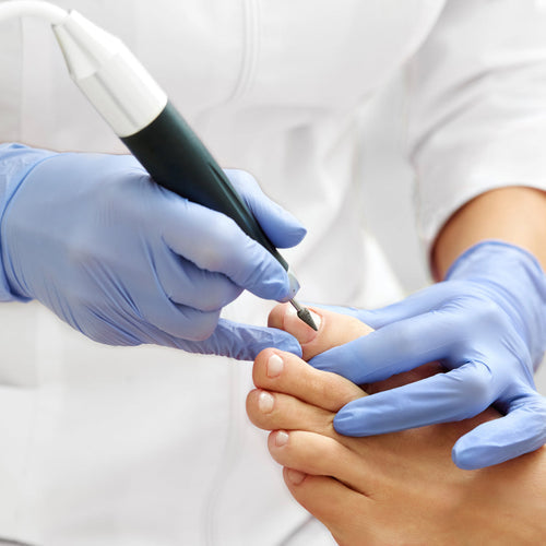 Podiatrist performing a medical pedicure for diabetic patient in sterile clinic